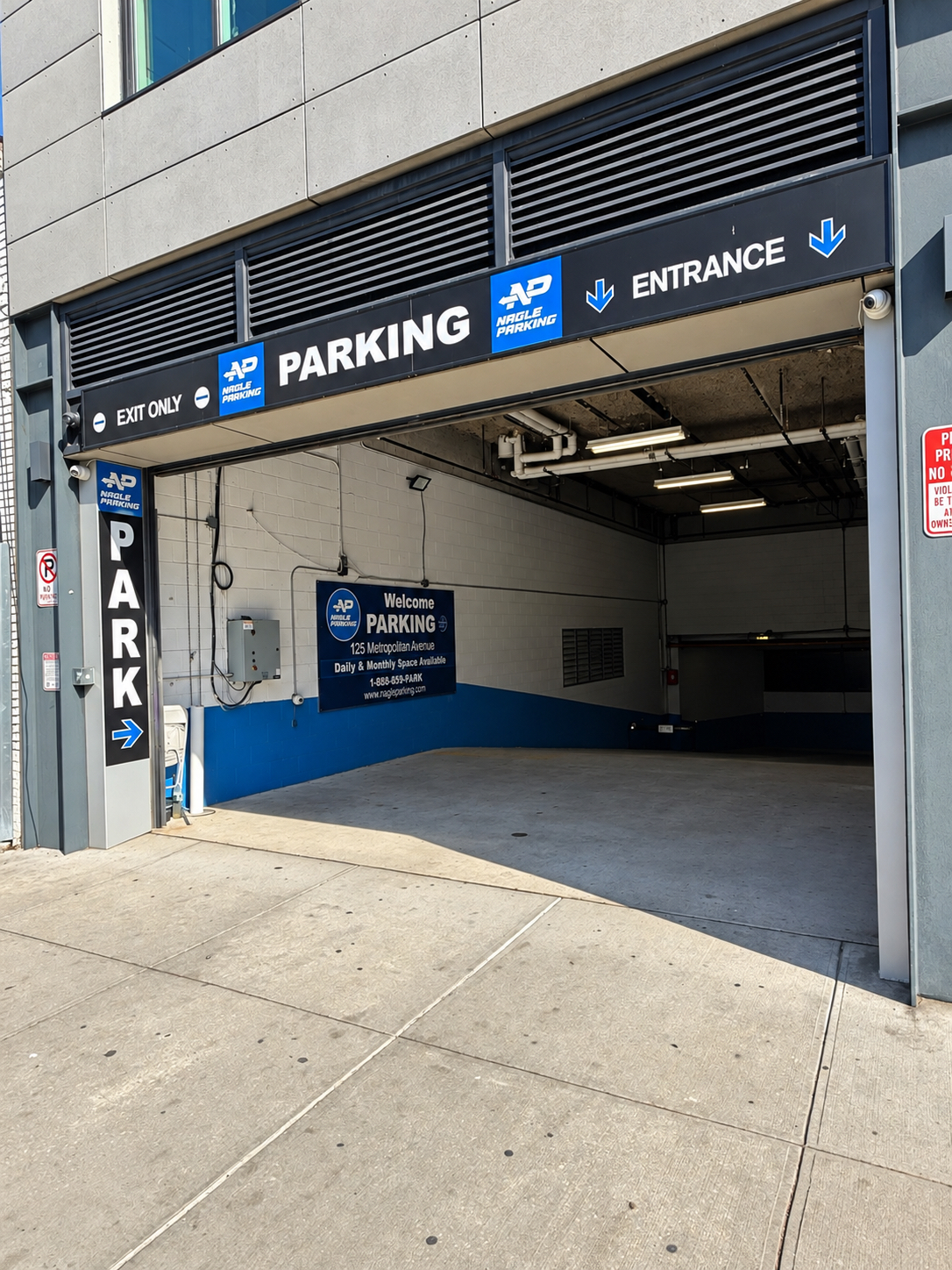 Angled view of the garage entrance and welcome sign at 125 Metropolitan Avenue