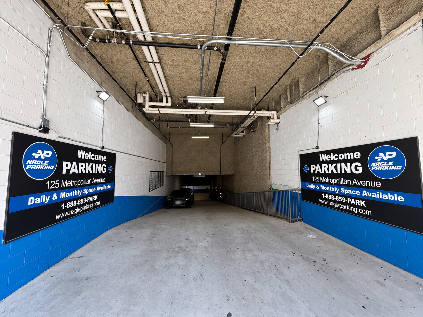 Entrance ramp with welcome signs leading into the garage at 125 Metropolitan Avenue